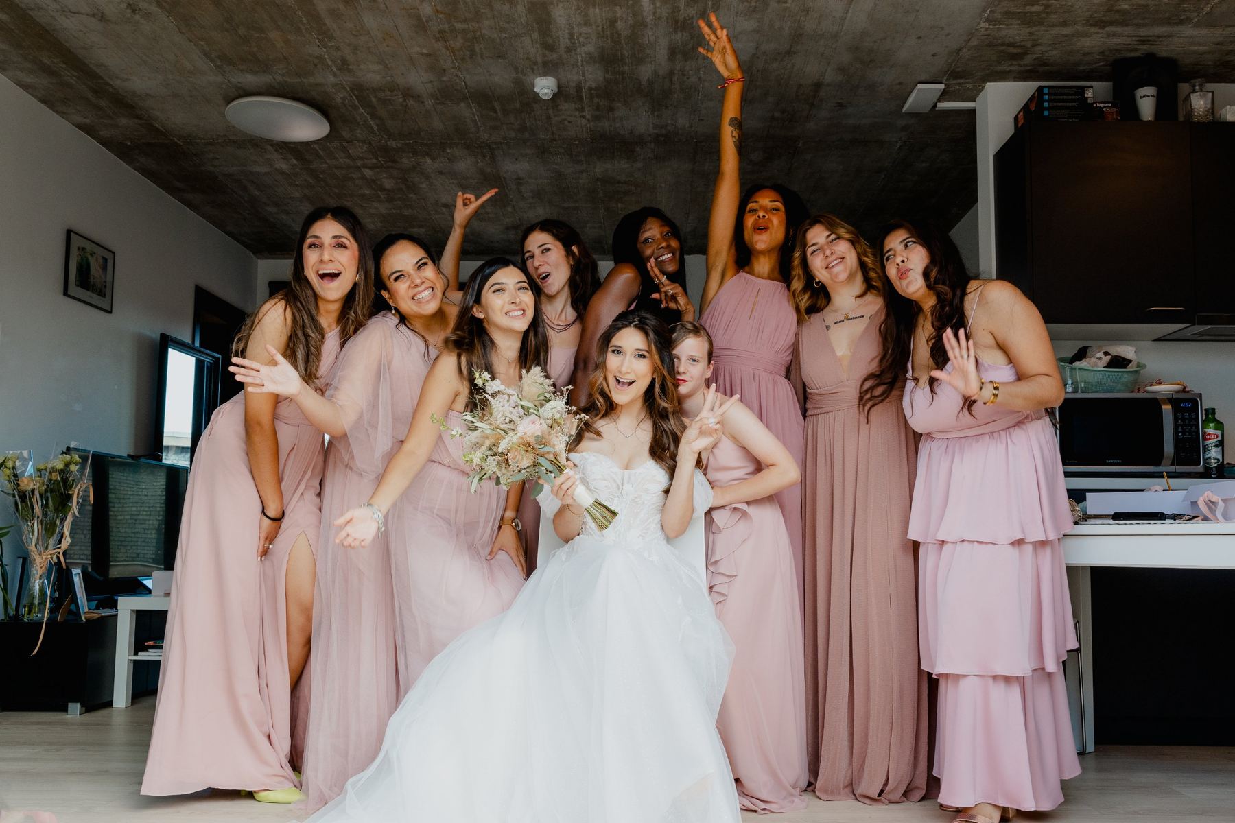 Bride cheering with her bridesmaids in pink