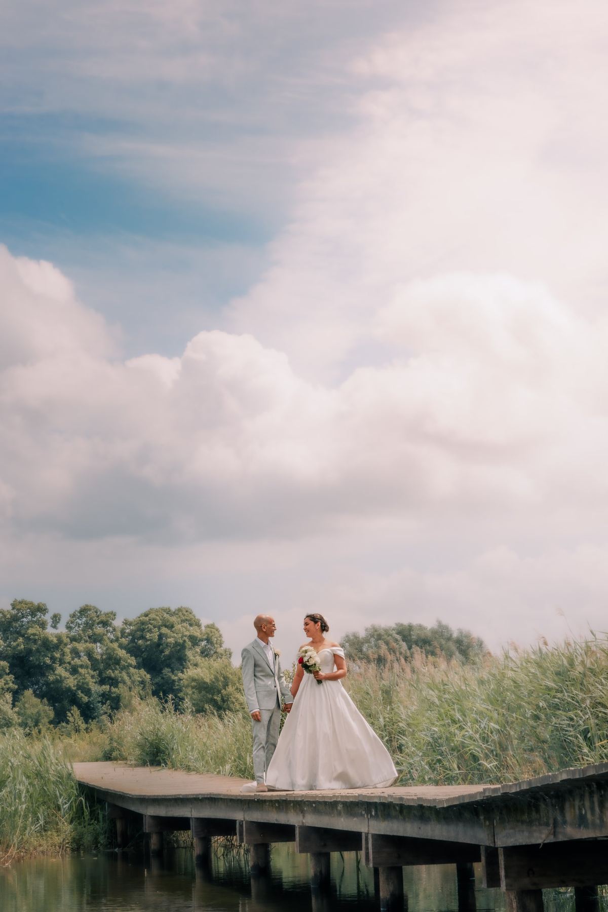 Couple on a wooden jetty under a big summer sky